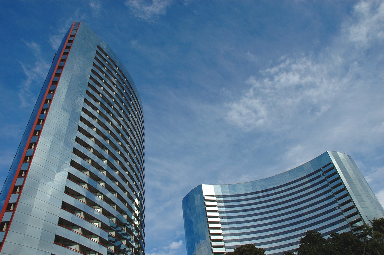 two curved office blocks, blue sky and trees